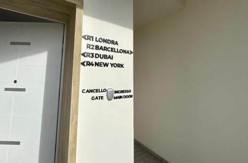 a wall with signs on it next to a door at Bari Airport Rooms in Bari
