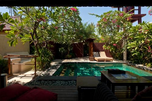 a swimming pool in the middle of a garden at Taman Senang - Private Pool Villas - Gili Air in Gili Air