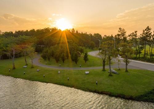 a park with the sun setting in the background at Rosee Villa - Green Villa with private Pool in Vĩnh Phúc
