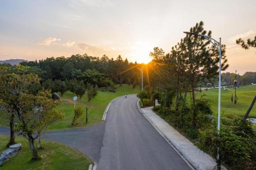 a road in a park with the sunset in the background at Rosee Villa - Green Villa with private Pool in Vĩnh Phúc