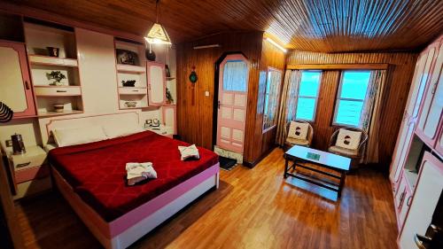 una camera con un letto in una stanza con pavimenti in legno di Yuma D Homestay a Darjeeling