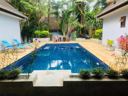 einen Pool im Hinterhof eines Hauses in der Unterkunft Pool Villas by Honey-5 miles from central Pattaya Beach in Nong Prue