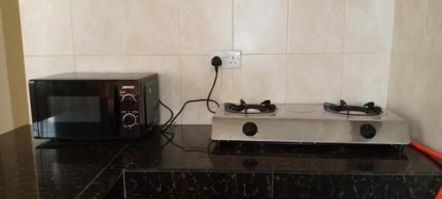 a toaster oven and a microwave on a counter at Alpha Homes in Kilifi