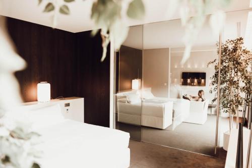 a bedroom with a mirror and a person sitting in a bed at Bdesign & Spa in Paradou