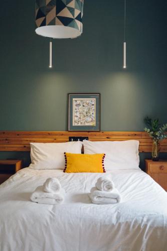 a bedroom with a white bed with towels on it at Llety Arall in Caernarfon