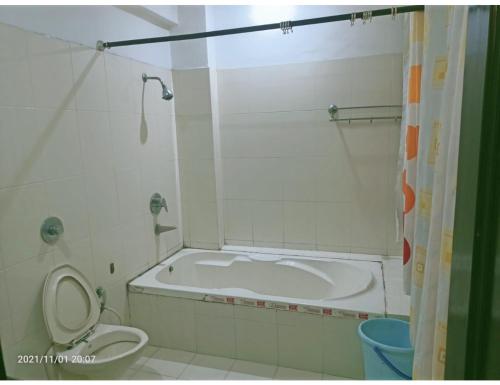 a bathroom with a tub and a toilet and a bath tub at Hotel Kishore International, Amritsar in Amritsar