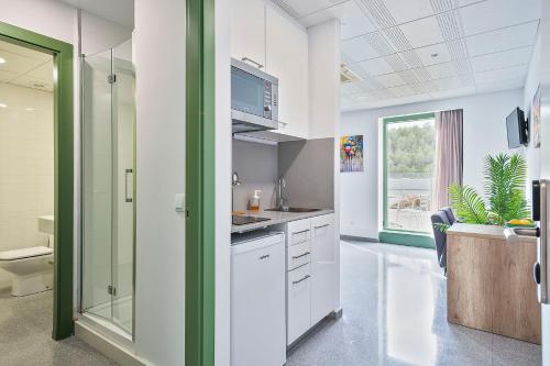 a kitchen with white cabinets and a sink and a window at Les Begues Apartments in Begues