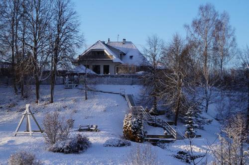 a house in the snow with a staircase in front at Jaunkrastmaļi in Kandava