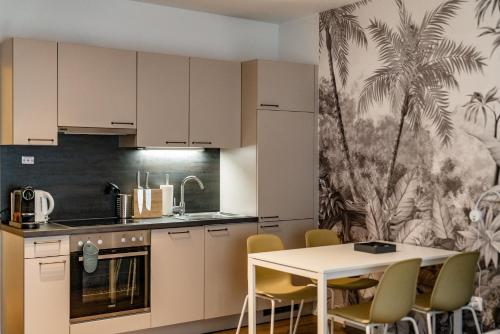 a kitchen with white cabinets and a table and chairs at APSTAY Eggenberg I Self Check-in I Parking option in Graz