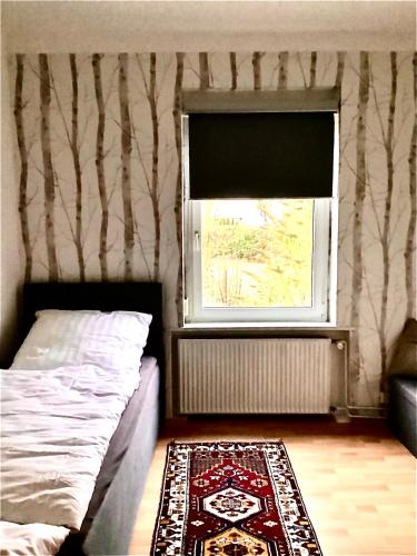 a bedroom with a bed and a window and a rug at Haus Lies in Rehfelde