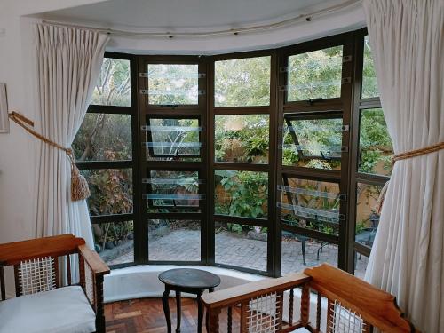 um quarto com uma grande janela com cortinas brancas em John Bauer Pottery Studio em Cidade do Cabo