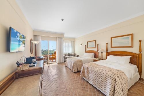 a hotel room with two beds and a television at The Cascades Golf Resort, Spa & Thalasso in Hurghada