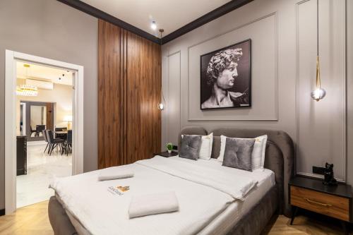 a bedroom with a large bed with a picture on the wall at LEOGRAND Apartments on Svobody Avenue 43 in Lviv