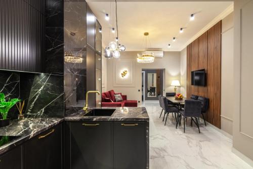 a kitchen with black cabinets and a dining room at LEOGRAND Apartments on Svobody Avenue 43 in Lviv