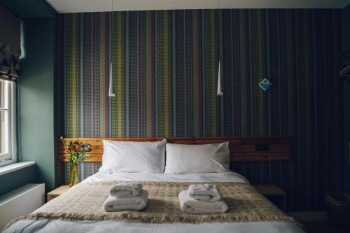 a bedroom with a bed with towels on it at Llety Arall in Caernarfon