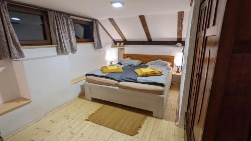 a bedroom with a bed with two yellow pillows on it at Chajdaloupka 