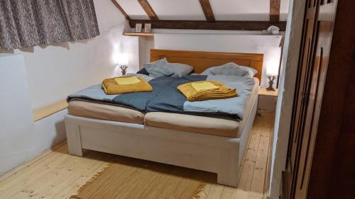 a bedroom with a bed with two yellow towels on it at Chajdaloupka 