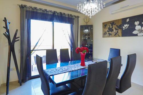 a dining room table with chairs and a vase of flowers at Villa Arbanassi in Lachi