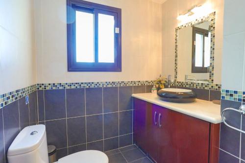 a bathroom with a toilet and a sink and a mirror at Villa Arbanassi in Lachi