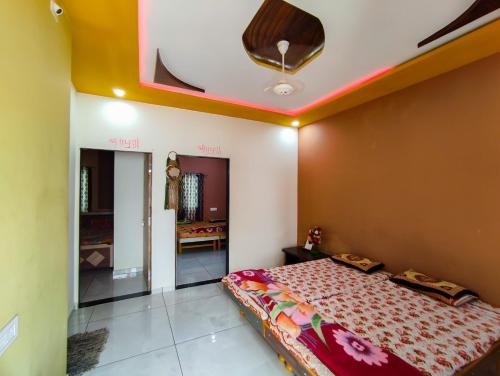 a bedroom with a bed and a ceiling at Bapa Sitaram Homestay in Garudeshwar