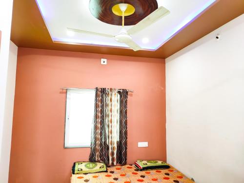 a bedroom with orange walls and a ceiling at Bapa Sitaram Homestay in Garudeshwar