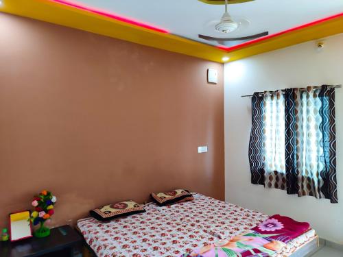 a bedroom with a bed with two pillows on it at Bapa Sitaram Homestay in Garudeshwar