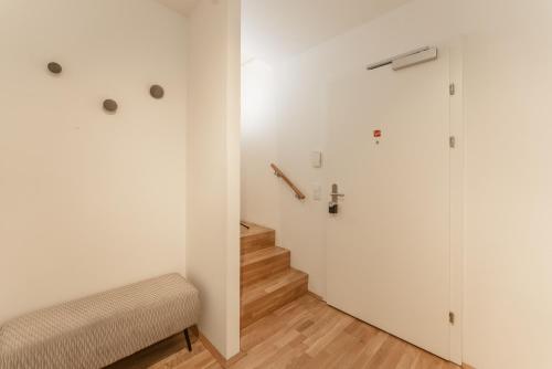 a room with a staircase and a white wall at APSTAY Eggenberg I Self Check-in I Parking option in Graz