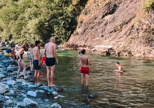 a group of people standing in the water at Te baca Qerim in Lekbibaj