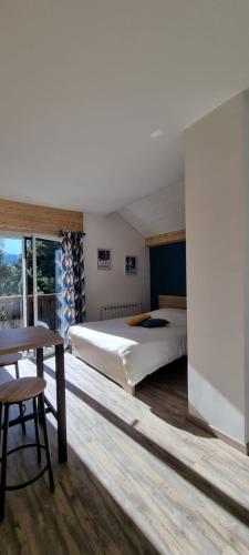 une chambre avec un grand lit et une table dans l'établissement Mont Bivouac, chambre,entrée et Sdb privée,balcon vue MtBlanc, à Passy