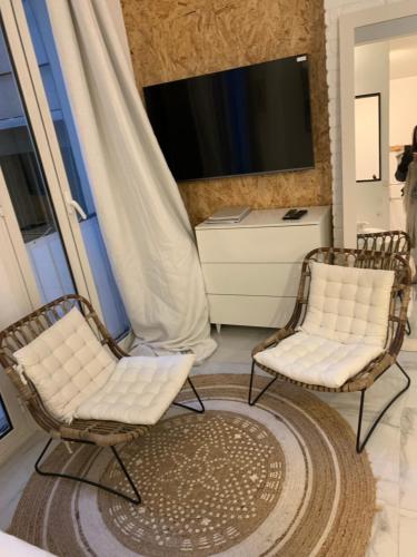 Duas cadeiras sentadas numa sala de estar com televisão em New Suite & SPA - Cannes Centre - Croisette em Cannes