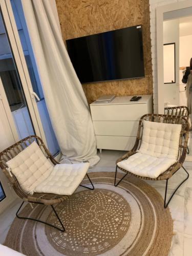 カンヌにあるNew Suite & SPA - Cannes Centre - Croisetteのリビングルーム(椅子2脚、テレビ付)