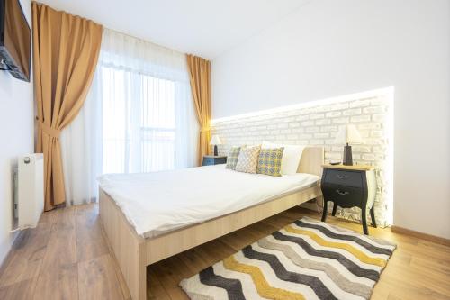 1 dormitorio con cama y pared de ladrillo en Brick Flats, en Oradea