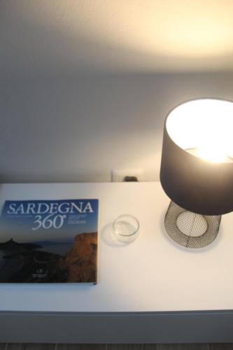 a lamp sitting on a table next to a box at Home Viale Trento 16 in Cagliari