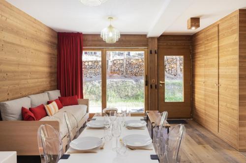 - une salle à manger avec une table et un canapé dans l'établissement appartement avec jardin dans luxueux chalet, à Zinal