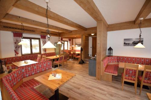 un ristorante con tavoli e divani in una stanza di Hotel Cafe Fuggerhof a Oberstdorf