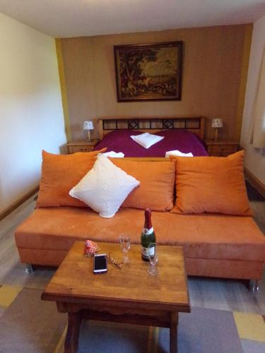 a bedroom with a bed with orange pillows and a table at Urlaubspension Die Mühle in Schöllnach