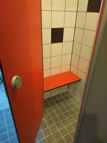 a stall with a red bench in a bathroom at Urlaubspension Die Mühle in Schöllnach