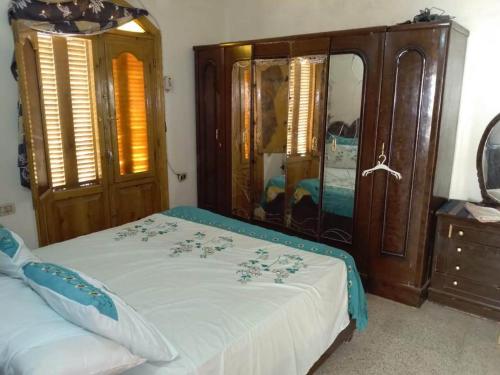 a bedroom with a bed and a wooden dresser at Zekry nubian guest house in Aswan