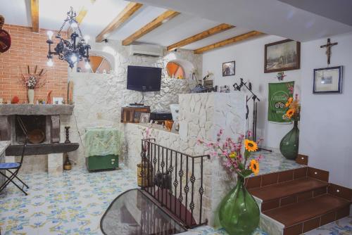 B&B Antico Palmento في ليباري: غرفة معيشة بها موقد وحائط حجري