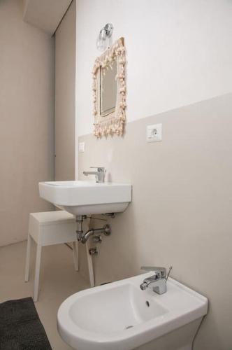 a white bathroom with a sink and a mirror at Villa Vendicari in Casa Maccari