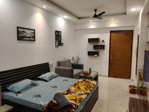 1 dormitorio con 1 cama y 1 silla en una habitación en The Forest Stays-Luxury Studio Apartment In Noida en Noida