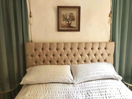 a bed with a tufted headboard in a bedroom at Beachfront apartment with wood burner & courtyard in St. Leonards