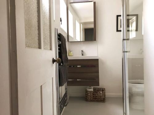 a bathroom with a white door and a sink at Beachfront apartment with wood burner & courtyard in St. Leonards