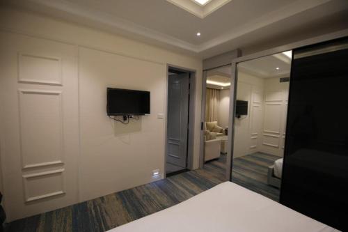 a hotel room with a tv on a wall at Enrise by Sayaji Rewa in Rewa