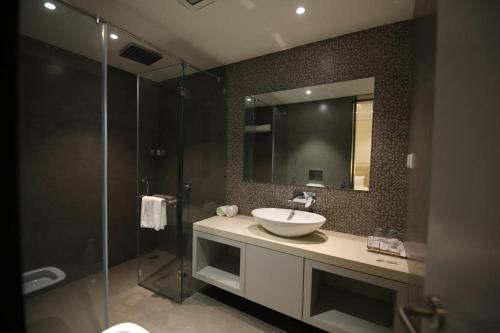 a bathroom with a sink and a glass shower at Enrise by Sayaji Rewa in Rewa