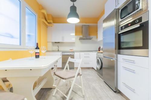 a kitchen with a white table and chairs at Etxeberria Park by Next Stop Bilbao in Bilbao