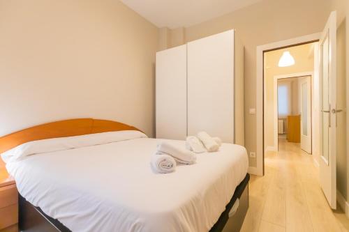 a bedroom with a white bed with towels on it at Etxeberria Park by Next Stop Bilbao in Bilbao