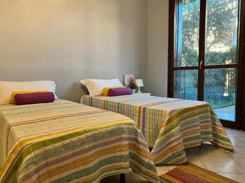 two beds sitting next to each other in a room at Bnbook-Casa Andrea in Cardano al Campo