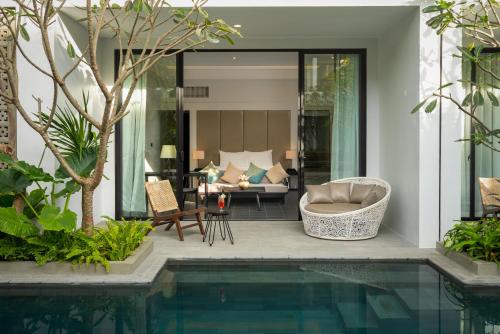 a house with a swimming pool and a living room at Eightfold Urban Resort in Siem Reap