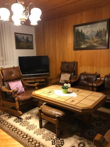 a living room with a table and chairs and a television at Ferienhaus Angelika in Arnoldstein